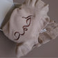 A ruffled hat with a brown decorative swirl design on top, set against a neutral backdrop, perfectly complements the soft Ruffled Blanket by BOBO BOUTIQUE.